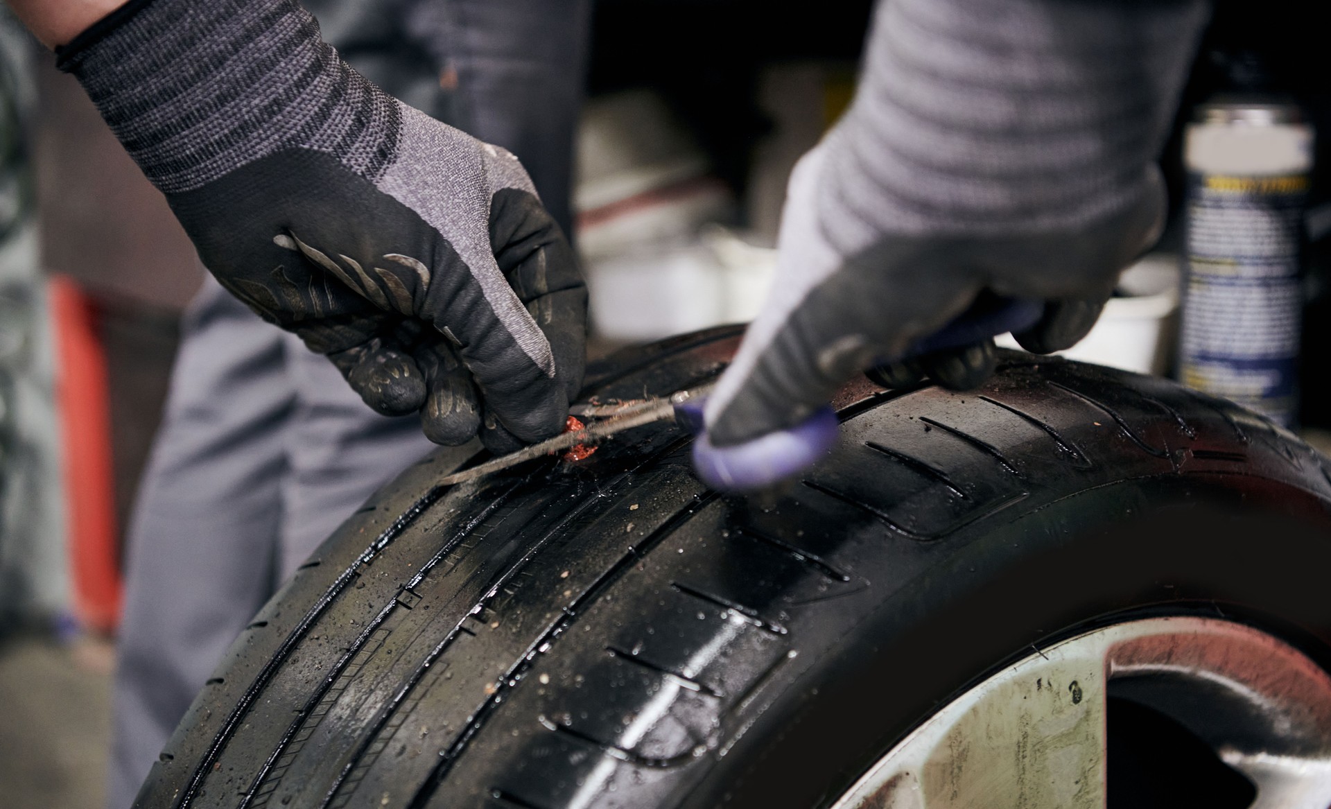 Vulcanizer Fixing a Punctured Hole by Inserting an Injection Mould before Injecting Natural Crude Rubber into a Used Punctured Tire in a Car Repair Shop Indoors